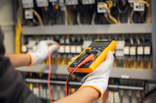 Electrician testing an electrical panel with a multimeter
